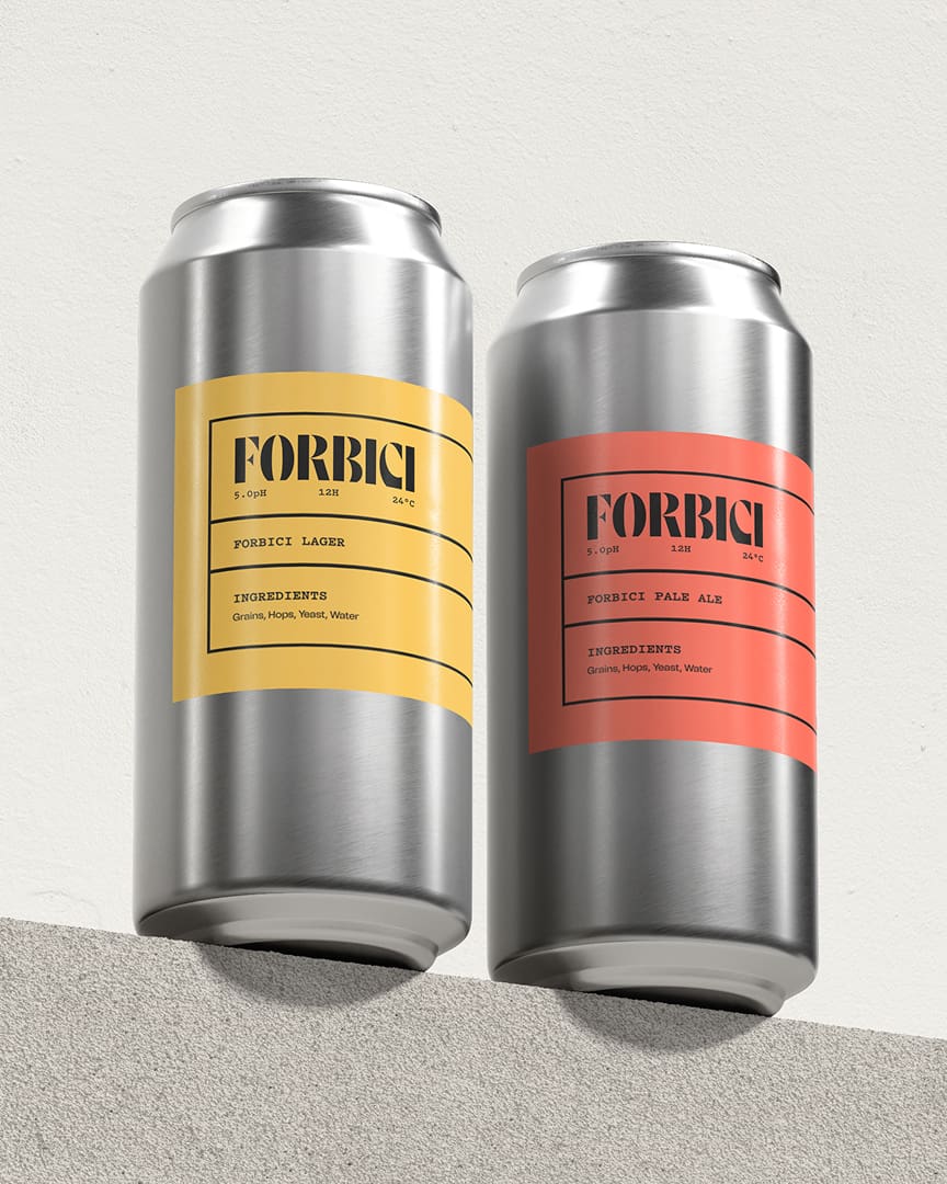 Two silver beer cans stand side by side, one with a yellow label reading "Forbic Lager" and the other with a red label reading "Forbic Pale Ale." Both labels list ingredients and have a minimalist design.
