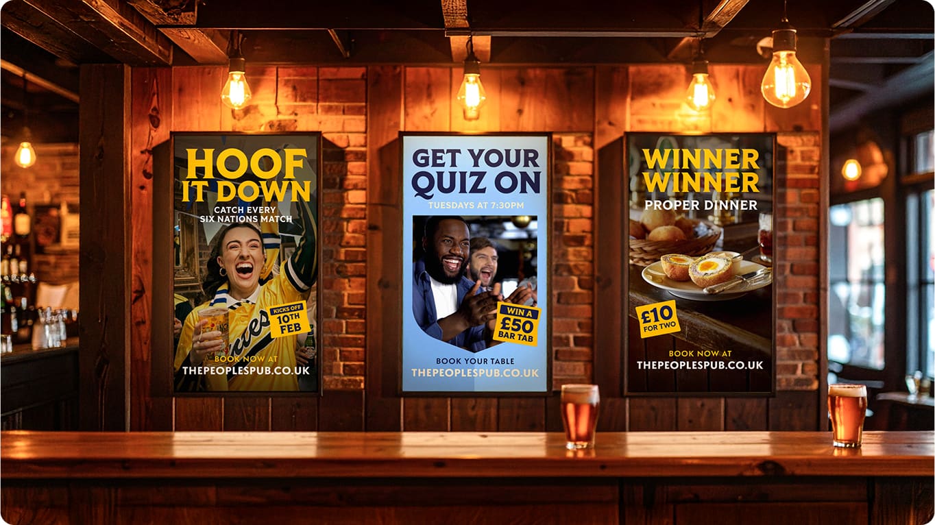 Three posters hang inside a cozy pub advertising events: a Six Nations rugby match, a quiz night, and a proper dinner deal. Pints of beer sit on the bar in the warm, wooden interior.