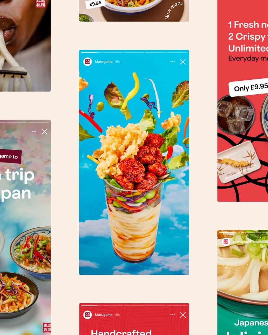 A vibrant food display with fried chicken, vegetables, and crispy toppings arranged in a clear cup filled with layered noodles and sauce, set against a bright blue sky background.